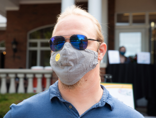 man wearing sunglasses and mask with smiley face
